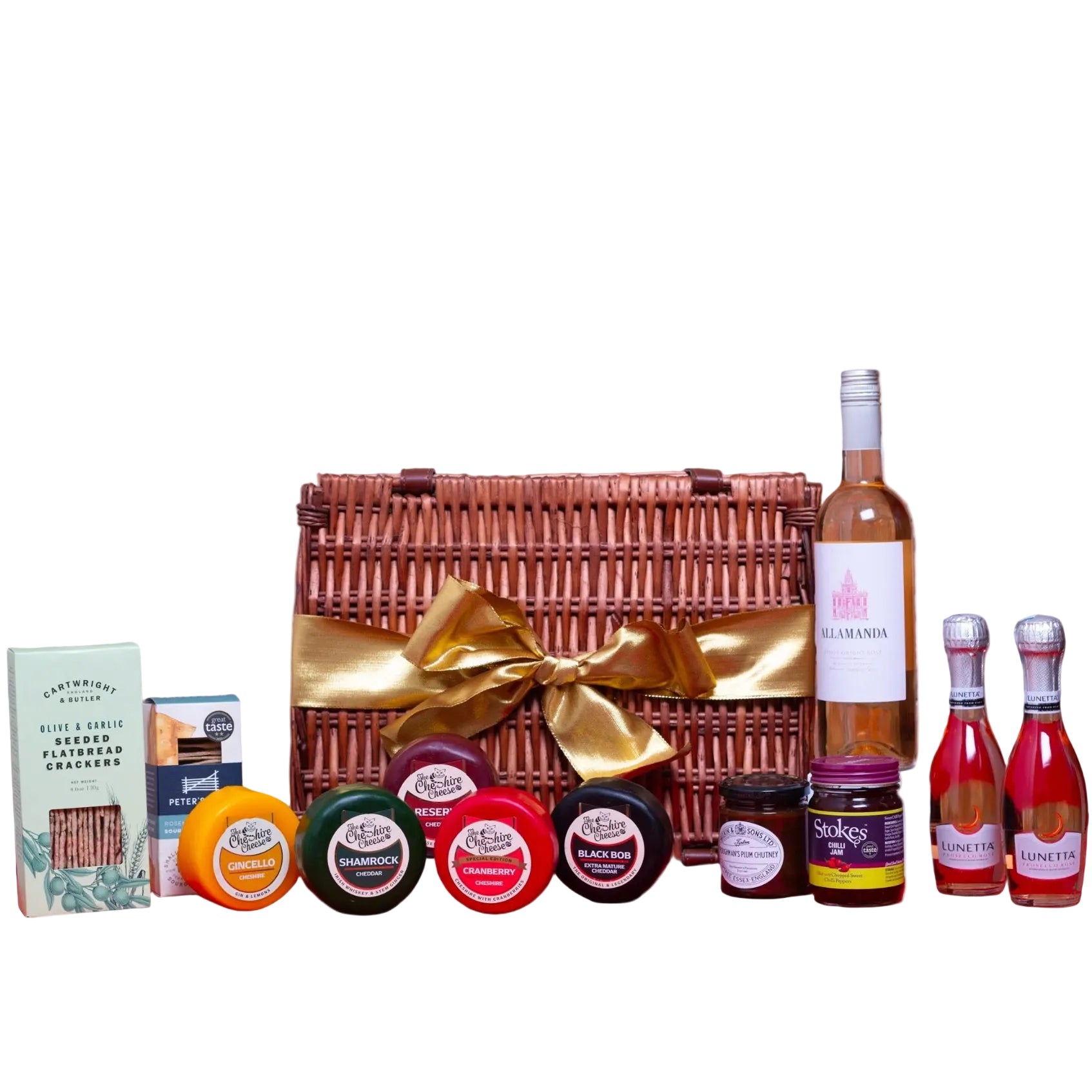 Gourmet gift basket with wine, jams, and other items against a brick wall.